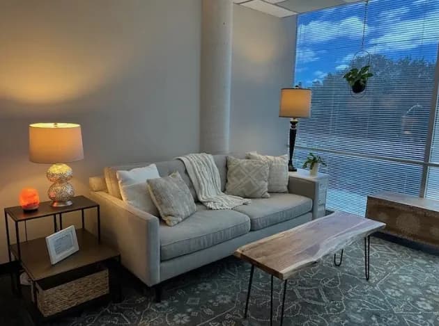 Sofa and side lamp in the therapy room, lit by the window behind